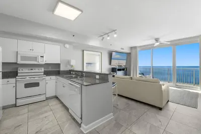 a kitchen with white appliances and a couch and a window at Shores Of Panama #1930 in Panama City Beach