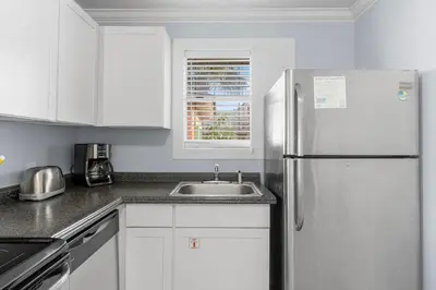 a kitchen with a white refrigerator and a sink at Salt Life Bungalow in Panama City Beach