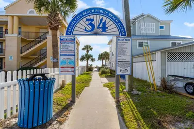 a sign for a beach resort with two trash cans at Salt Life Bungalow in Panama City Beach