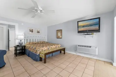 a bedroom with a bed and a tv on the wall at Salt Life Bungalow in Panama City Beach