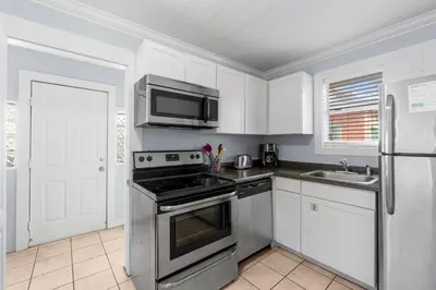 a kitchen with a stove and a microwave at Salt Life Bungalow in Panama City Beach