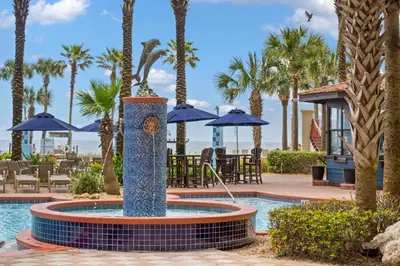 a fountain in the middle of a pool with palm trees at Shores Of Panama #1830 in Panama City Beach