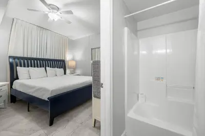 a bedroom with a bed with a ceiling fan and a shower at Shores Of Panama #1830 in Panama City Beach
