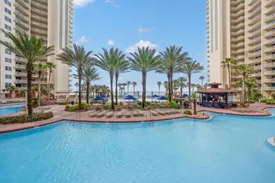 a swimming pool at a resort with palm trees and buildings at Shores Of Panama #1927 in Panama City Beach