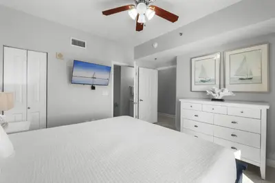 a white bedroom with a bed and a ceiling fan at Shores Of Panama #1927 in Panama City Beach