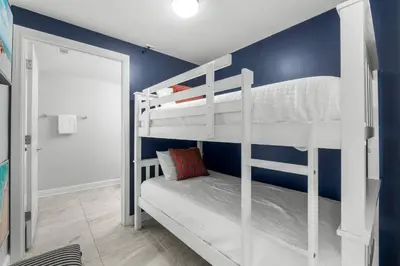a bedroom with two bunk beds and a blue wall at Shores Of Panama #1926 in Panama City Beach