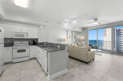 a kitchen with white appliances and a living room at Shores Of Panama #1926 in Panama City Beach