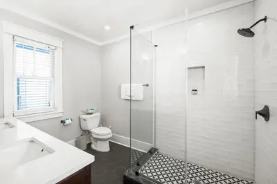 a bathroom with a toilet and a glass shower at Captain Jack Cottage in Rosemary Beach