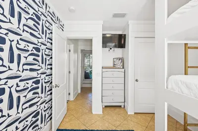 a bedroom with a blue and white patterned wall at Captain Jack Cottage in Rosemary Beach