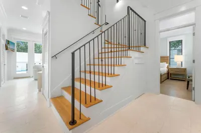 a staircase in a home with white walls at Chloe's Cottage and Carriage House in Rosemary Beach