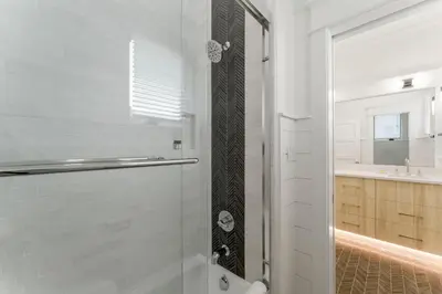 a bathroom with a shower with a glass door at Chloe's Cottage and Carriage House in Rosemary Beach