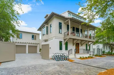 a large white house with a large driveway at Chloe's Cottage and Carriage House in Rosemary Beach