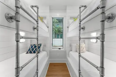 a room with two bunk beds and a window at Chloe's Cottage and Carriage House in Rosemary Beach