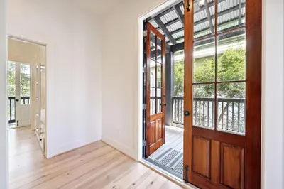 an empty room with a door and a balcony at Rose Cottage in Rosemary Beach
