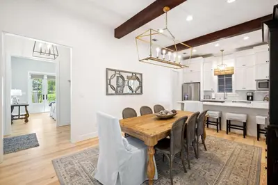 a kitchen and dining room with a wooden table and chairs at Rose Cottage in Rosemary Beach