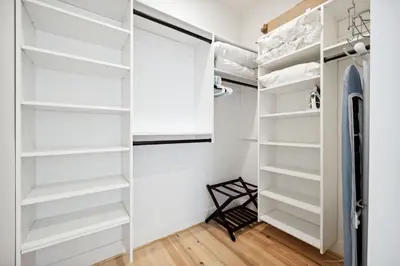 a walk in closet with white shelves at Rose Cottage in Rosemary Beach