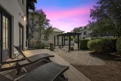 a patio with a chair and a table at Rose Cottage in Rosemary Beach