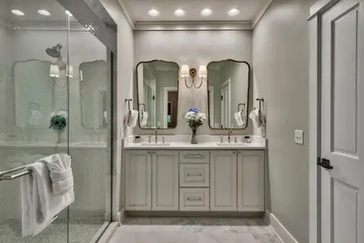 a bathroom with two sinks and a glass shower at Julia's Cottage in Rosemary Beach