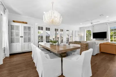 a dining room with a table and white chairs at Abaco Pearl Cottage in Rosemary Beach