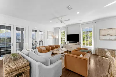 a living room with a couch and chairs and a tv at Abaco Pearl Cottage in Rosemary Beach