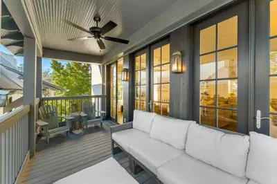 a porch with a white couch on a balcony at Abaco Pearl Cottage in Rosemary Beach