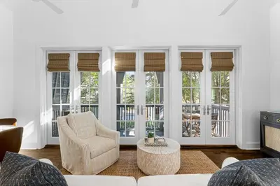 a living room with a couch and chairs and windows at Abaco Pearl Carriage House in Rosemary Beach
