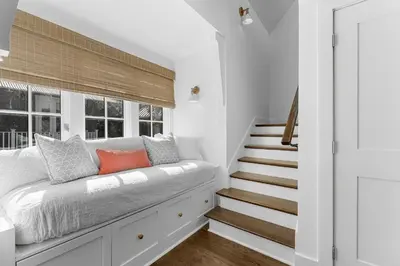 a white room with a bed and a window at Abaco Pearl Carriage House in Rosemary Beach