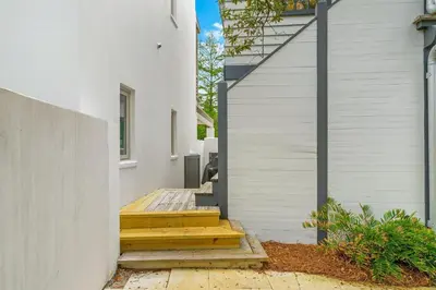 a house with wooden steps leading up to a building at Julia's Carriage House in Rosemary Beach