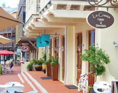 a street with tables and chairs on a sidewalk at Julia's Carriage House in Rosemary Beach