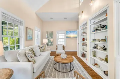 a living room with a white couch and a table at Julia's Carriage House in Rosemary Beach