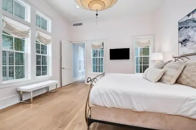 a white bedroom with a bed and windows at Chalet by the Sea in Santa Rosa Beach