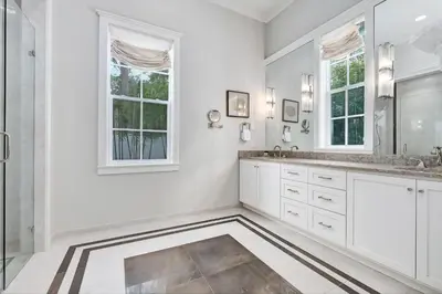 a white bathroom with two sinks and a mirror at Chalet by the Sea in Santa Rosa Beach