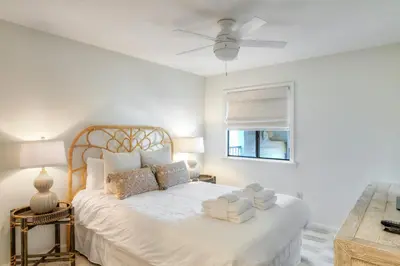 a bedroom with a white bed with a ceiling fan at Seamist #8 in Seacrest
