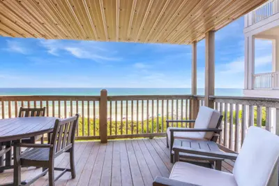 a deck with a table and chairs and the ocean at Seamist #8 in Seacrest