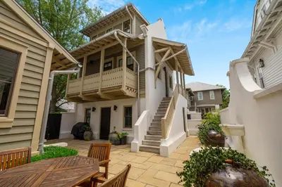 a house with a balcony and a patio at PTO Carriage House in Rosemary Beach