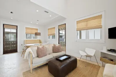 a living room with a couch and a table at PTO Carriage House in Rosemary Beach
