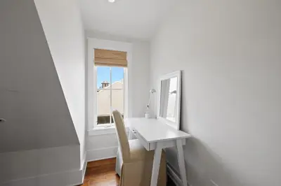 a white desk and mirror in a room with a window at PTO Carriage House in Rosemary Beach