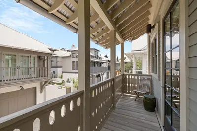an outdoor deck with a pergola and a bench at PTO Carriage House in Rosemary Beach