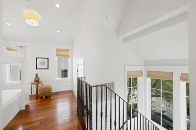 a white hallway with a staircase in a house at PTO Carriage House in Rosemary Beach