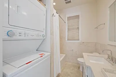 a white bathroom with a sink and a toilet at PTO Carriage House in Rosemary Beach