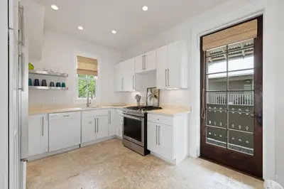 a kitchen with white cabinets and a stove top oven at PTO Carriage House in Rosemary Beach