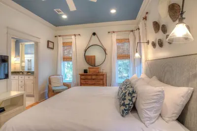 a bedroom with a large white bed and a mirror at Out of Bounds in Santa Rosa Beach