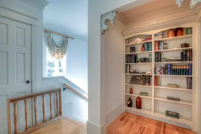 a staircase in a home with bookshelves at Out of Bounds in Santa Rosa Beach