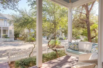 a porch with a swing and a fence at Out of Bounds in Santa Rosa Beach