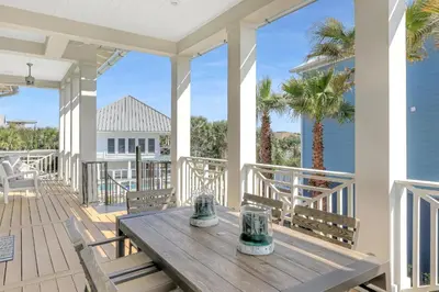 a wooden table on the front porch of a house at Patience Cottage in Santa Rosa Beach