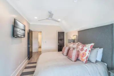 a bedroom with a large bed with colorful pillows at Patience Cottage in Santa Rosa Beach