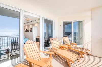 a group of chairs on a balcony with the ocean at High Pointe 32W in Rosemary Beach