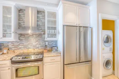 a kitchen with a refrigerator and a washer and dryer at High Pointe 32W in Rosemary Beach