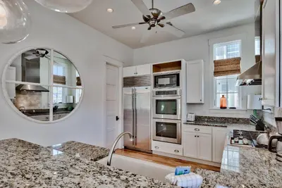 a kitchen with a ceiling fan and a mirror at Bella Cottage in Rosemary Beach