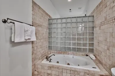 a bath tub in a bathroom with a tile wall at Bella Cottage in Rosemary Beach